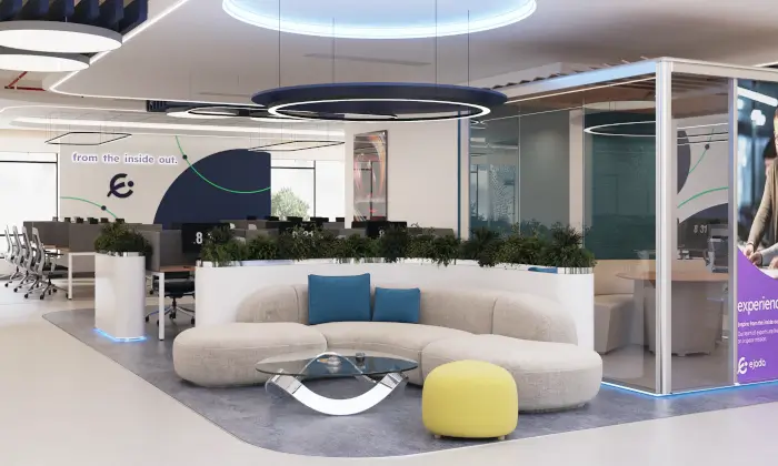 Modern office lounge with white sofa, blue cushions, yellow ottoman, glass table, and greenery in a contemporary workspace.
