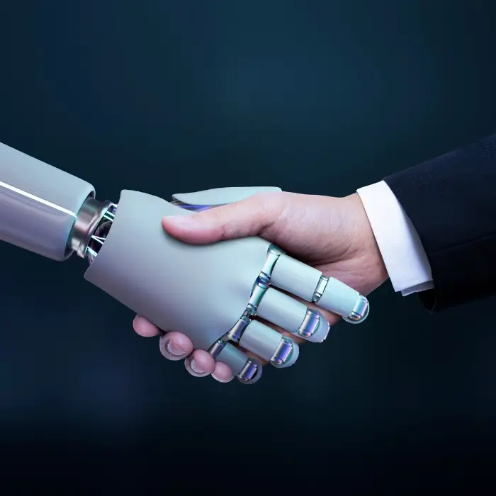 A human hand shakes hands with a robotic hand, symbolizing collaboration between humans and technology against a dark blue background.
