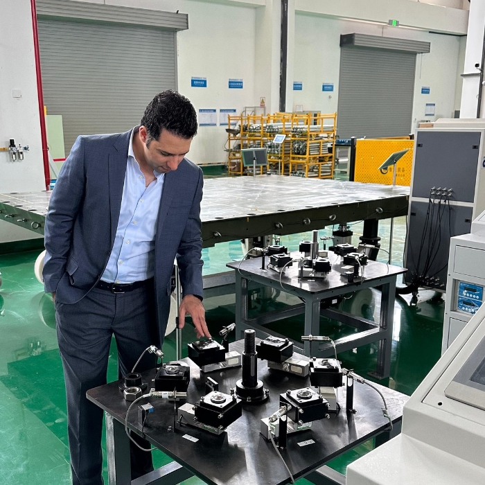 Mahmoud Zohny, CEO of ZF Holding, observing machinery components at ZEMIC factory, China.
