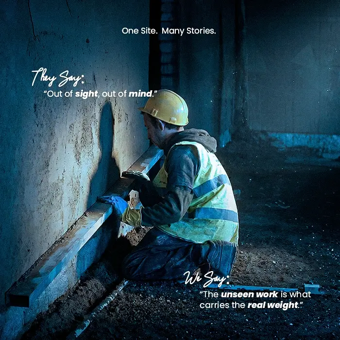 Construction worker performing detailed finishing work near the base of a wall at a ZF Holding project site during Labor Day 2026, with the message “The unseen work is what matters.